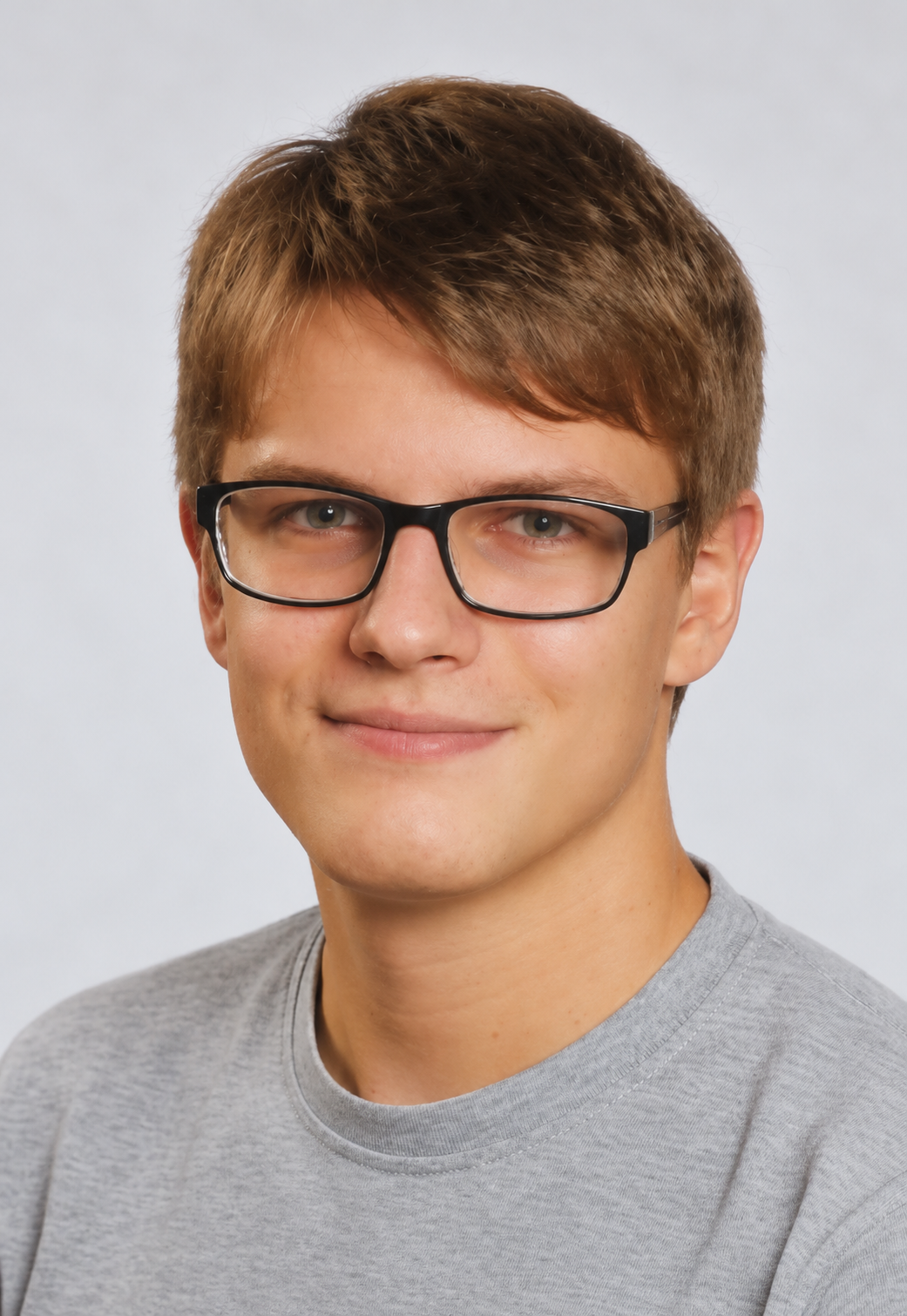 Porträtaufnahme eines jungen Mannes mit Brille vor hellem Hintergrund.