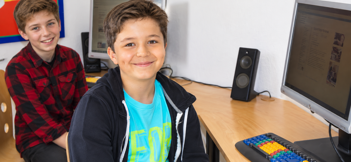Zwei Lernende an einem Computerarbeitsplatz im Unterrichtsraum